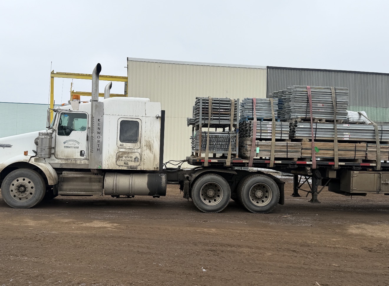 Flatbed loaded with scaffolding and structural steel components